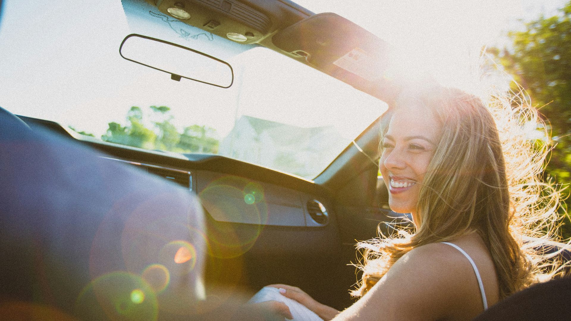 smiling woman sitting inside the vehicle at daytime
