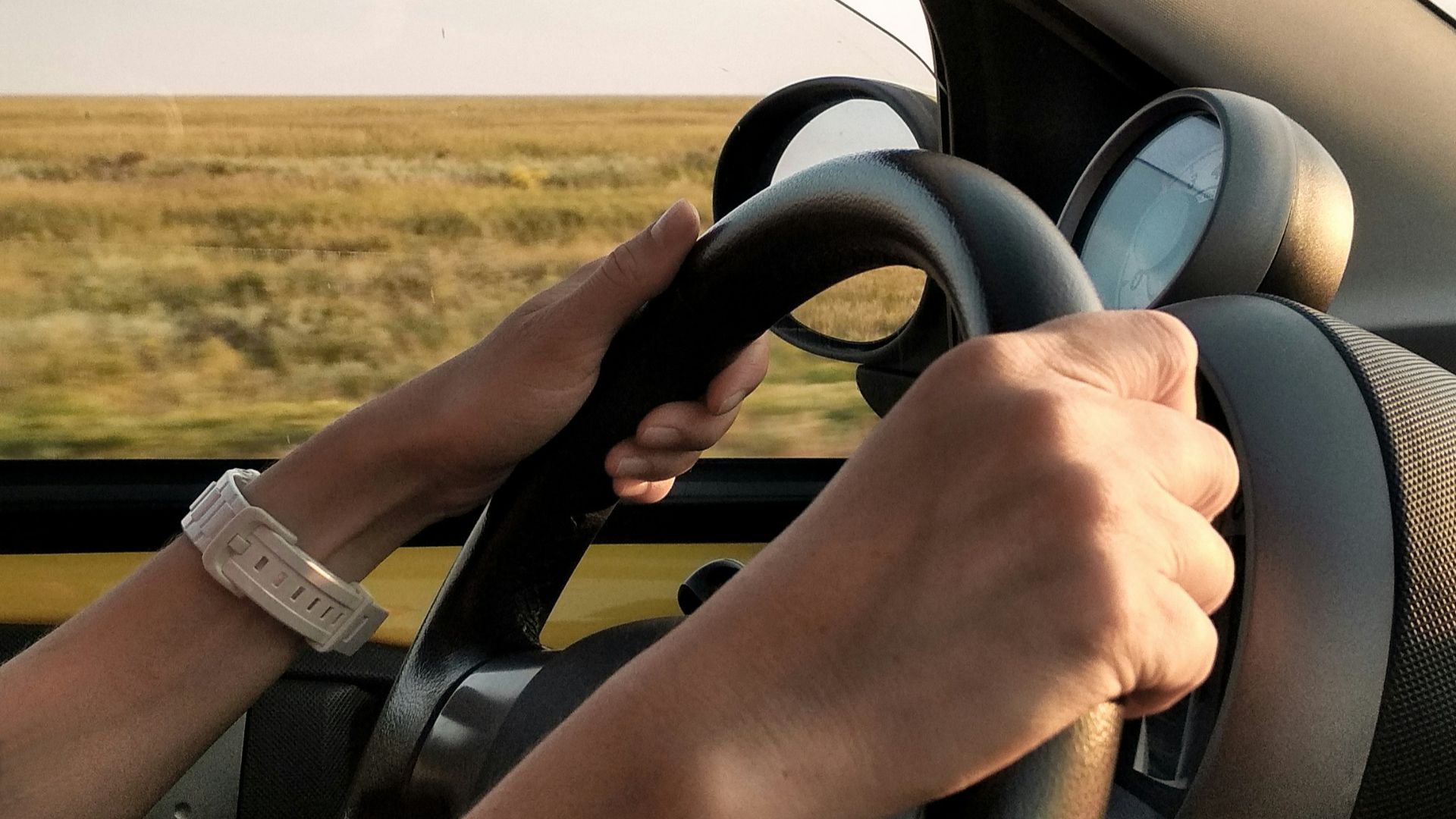 person with white watch driving car