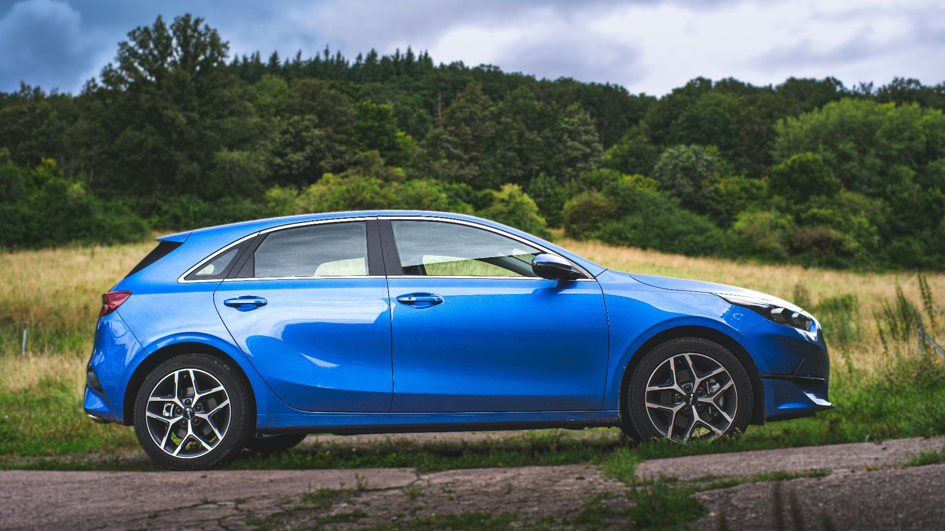 A blue car parked on the side of a road