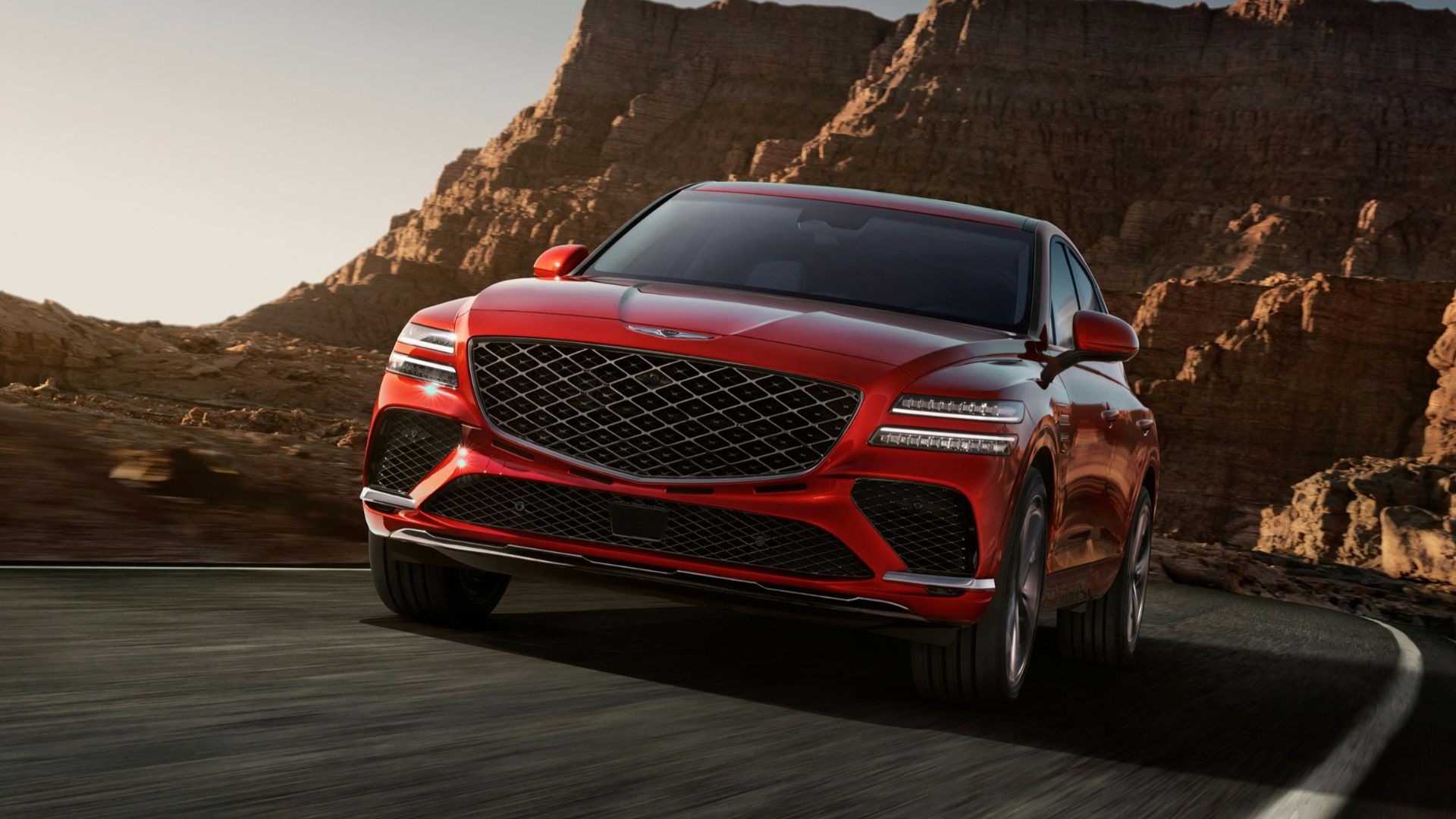 a red mercedes suv driving down a mountain road