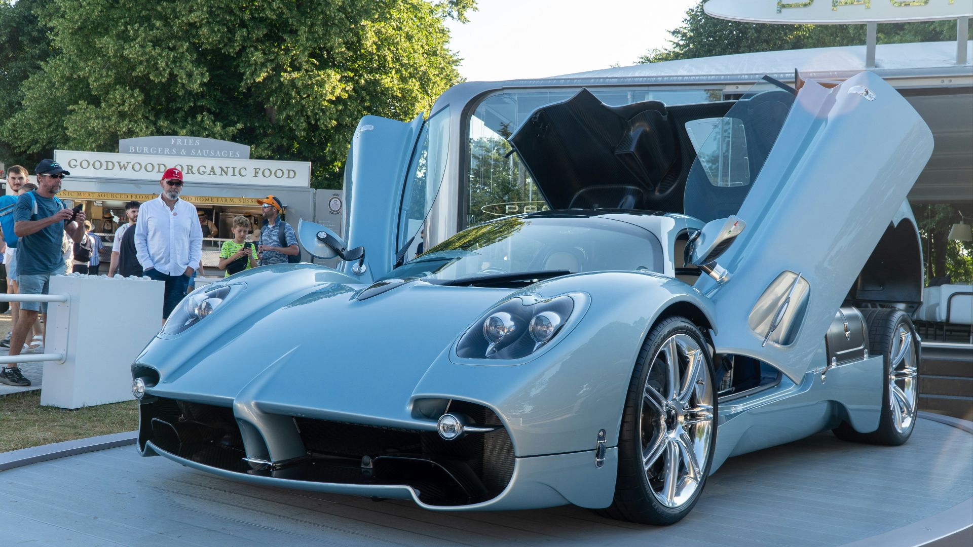 A luxurious blue sports car with doors open.