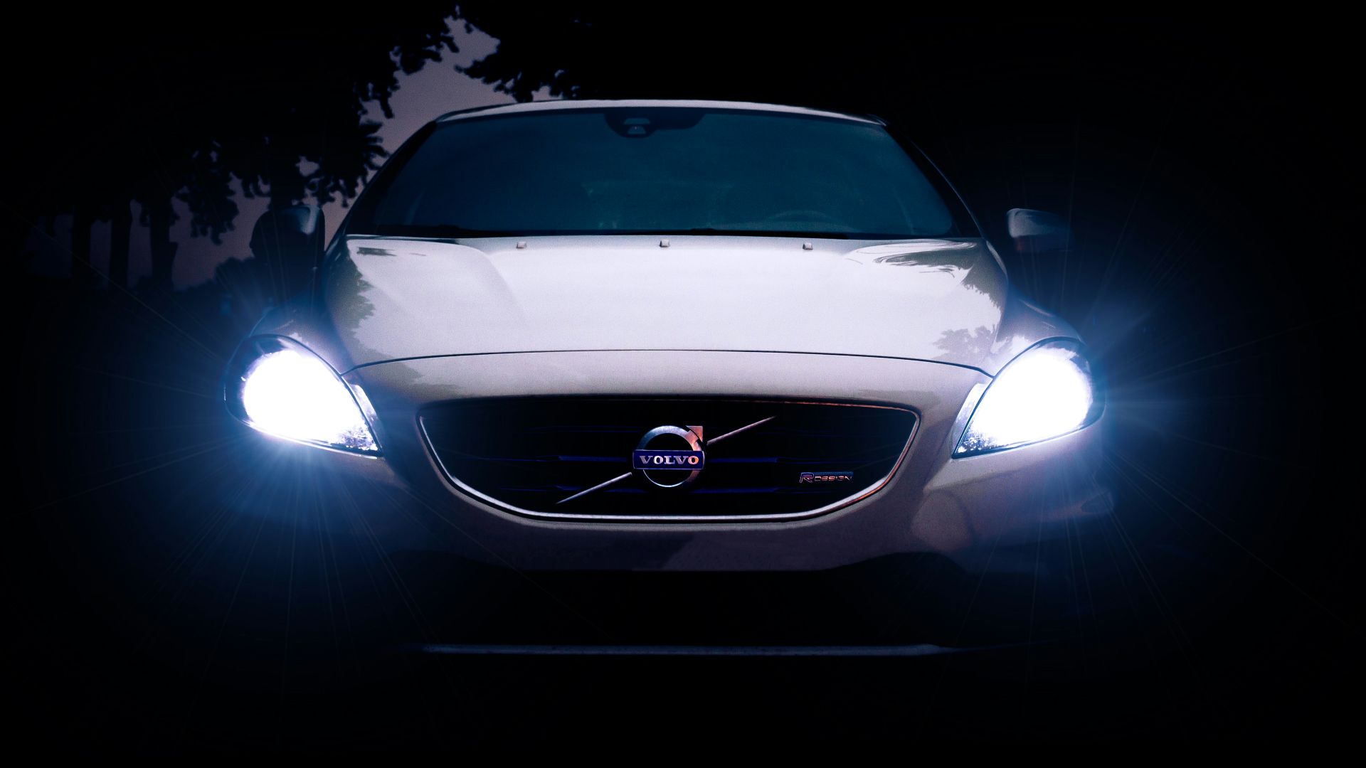 silver Volvo car with headlights on during night