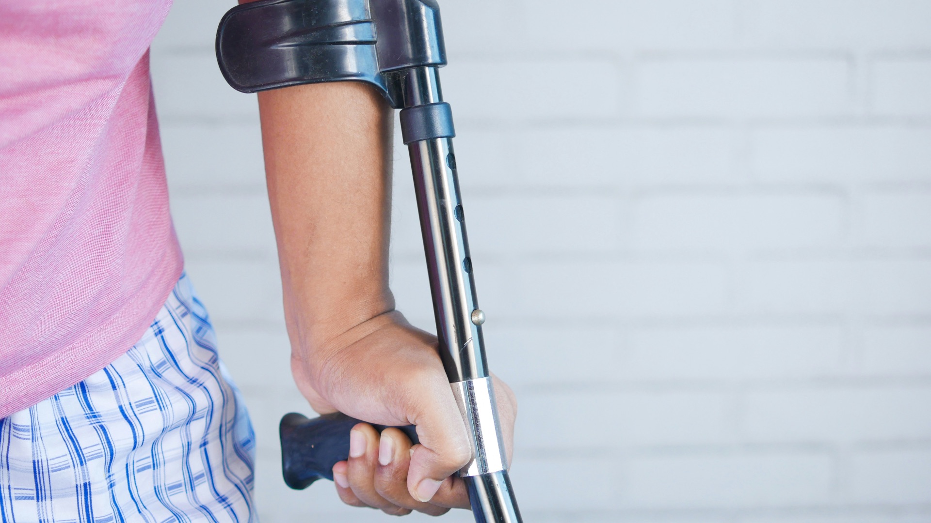 a person holding a crutch and walking cane