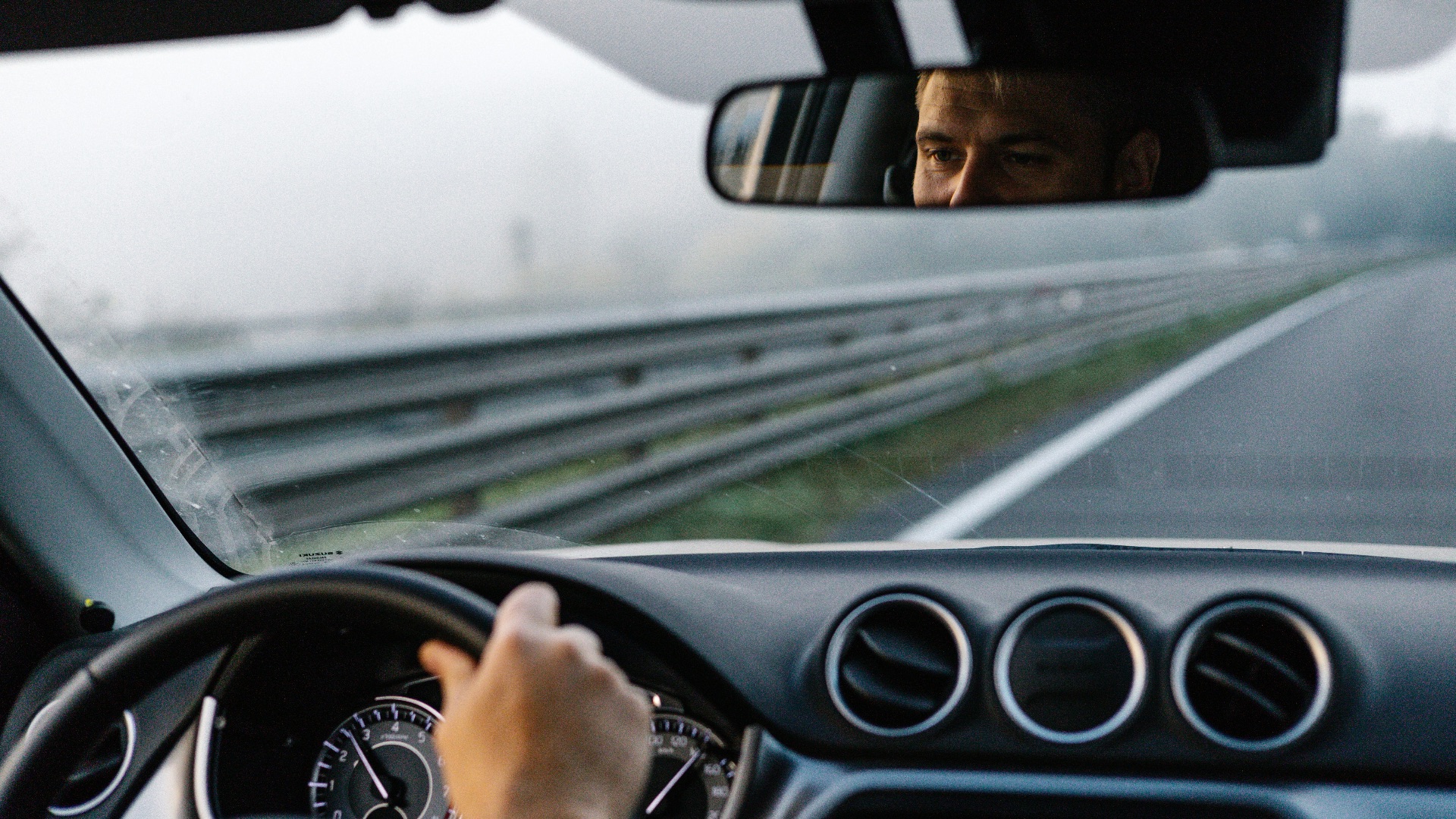 a man driving a car on a highway