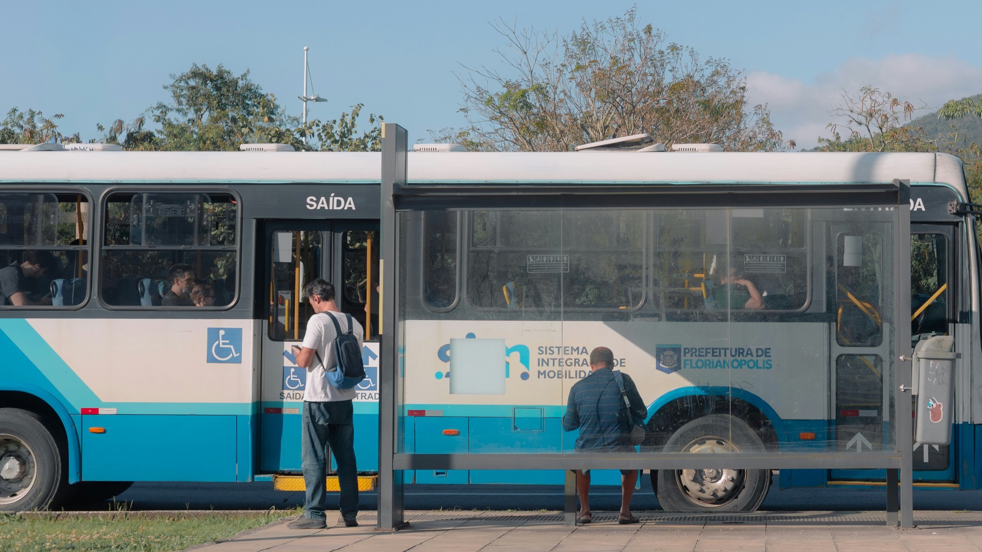 People waiting at a bus stop next to a bus.