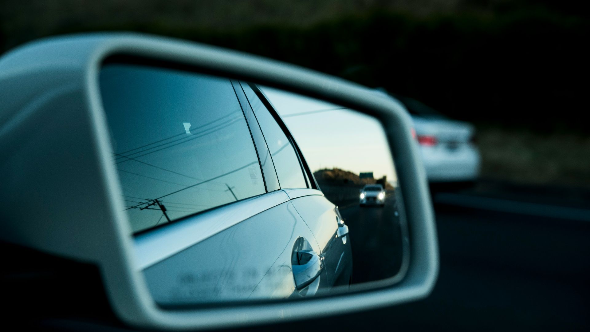 a rear view mirror on a car reflecting a street
