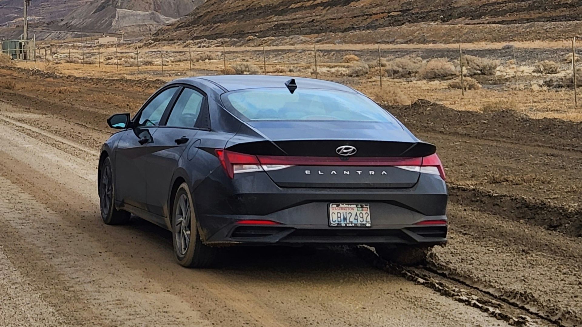 a car parked on a dirt road in the middle of nowhere