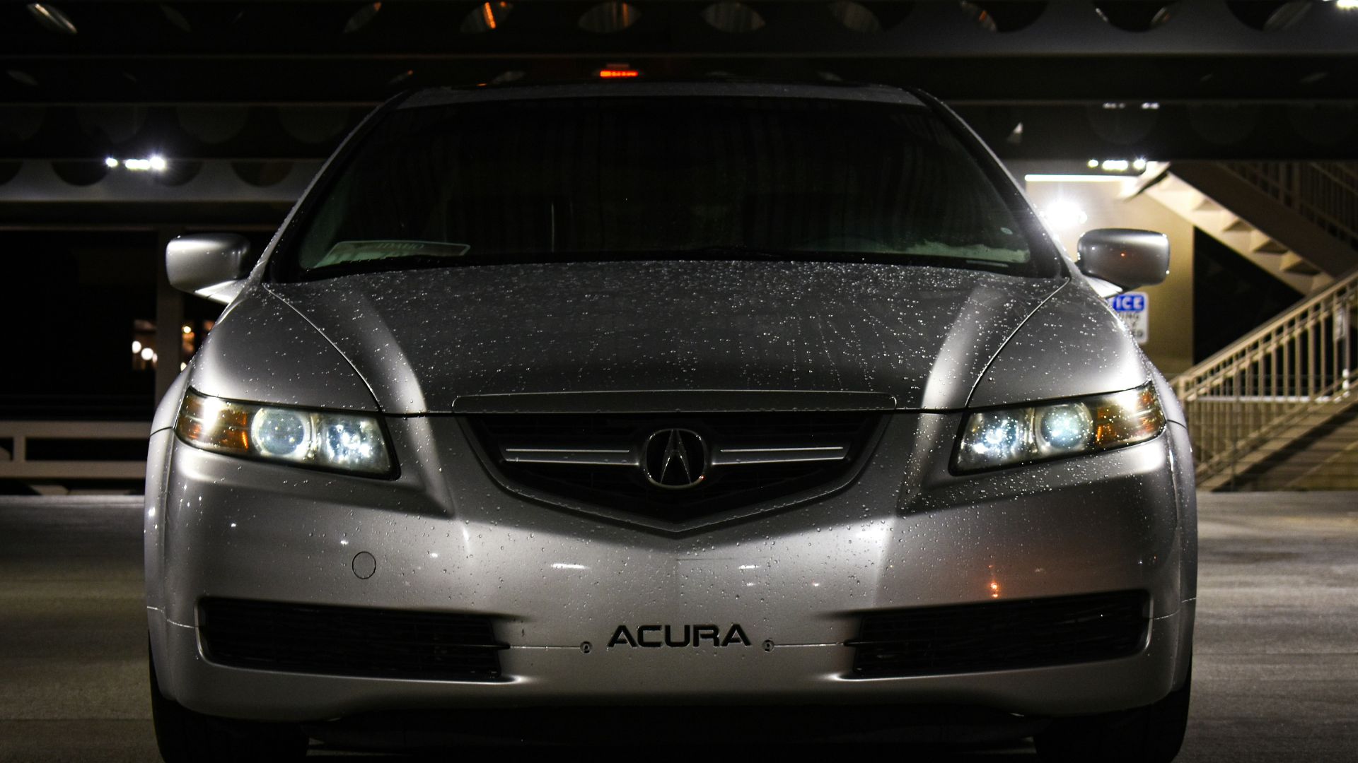 a silver acura car parked in a parking garage
