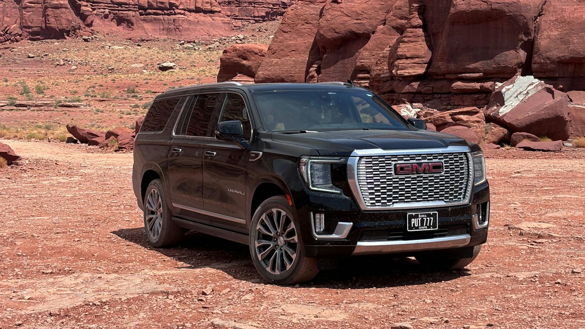 Black suv parked in a rocky desert landscape.