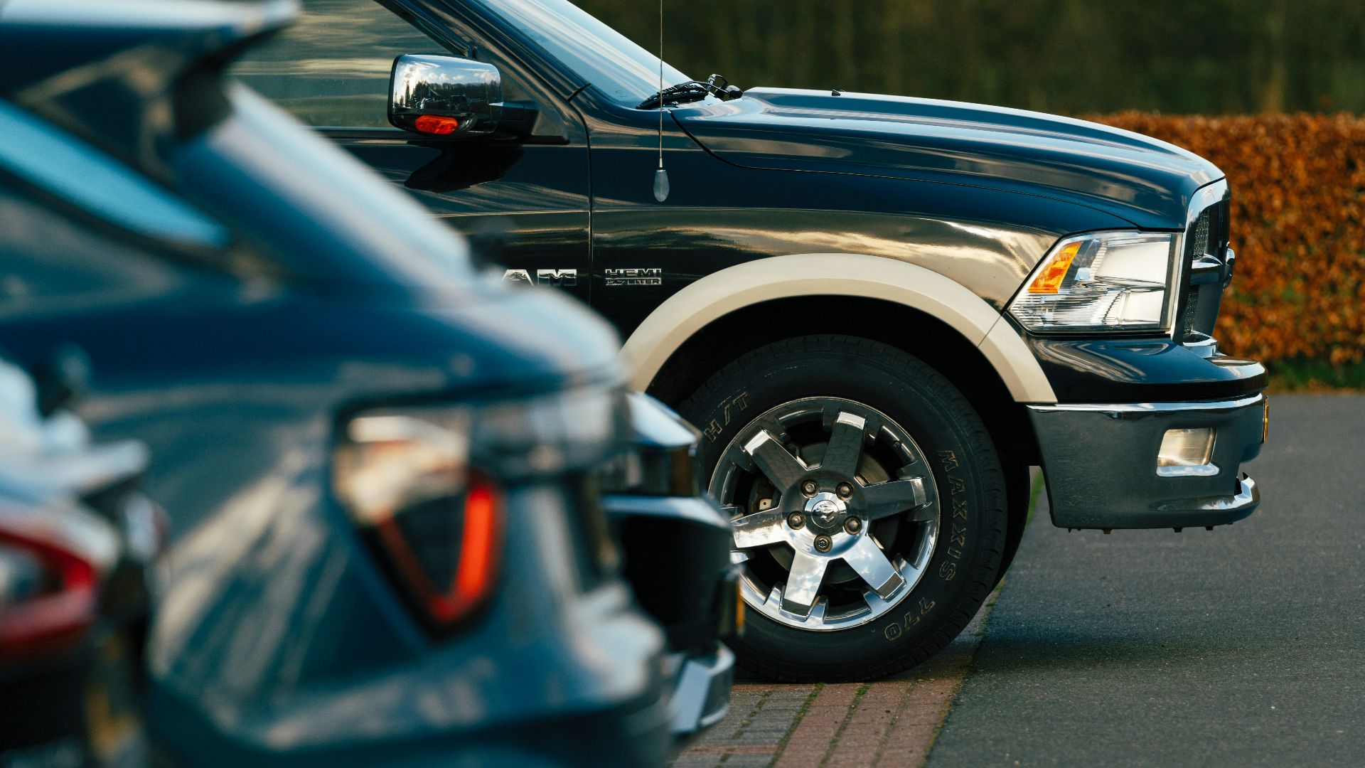 Cars of different sizes parked in a row.
