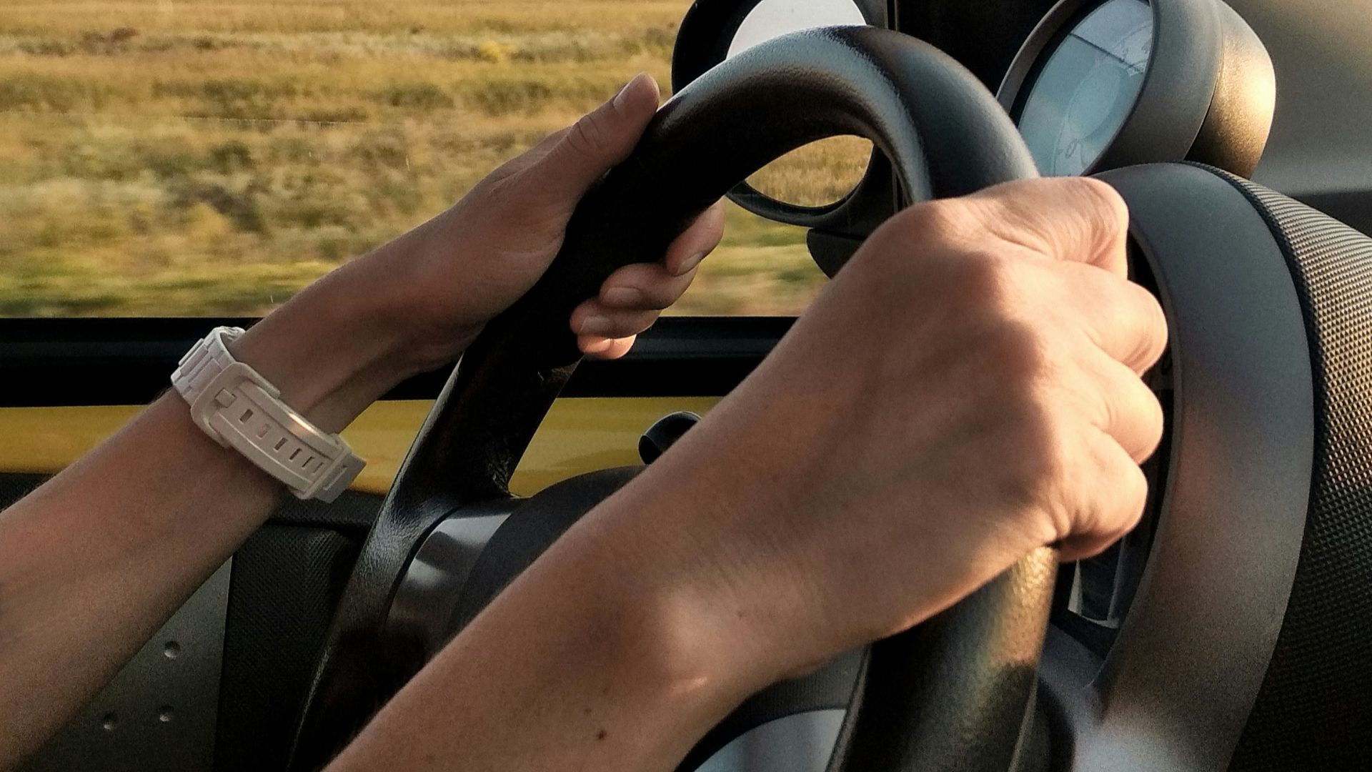 person with white watch driving car