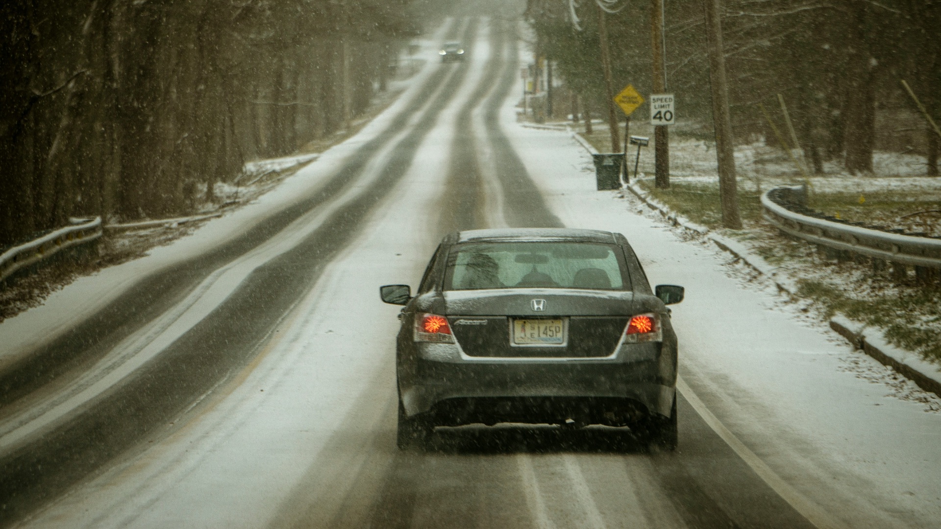 black car on road covered with snow during daytime