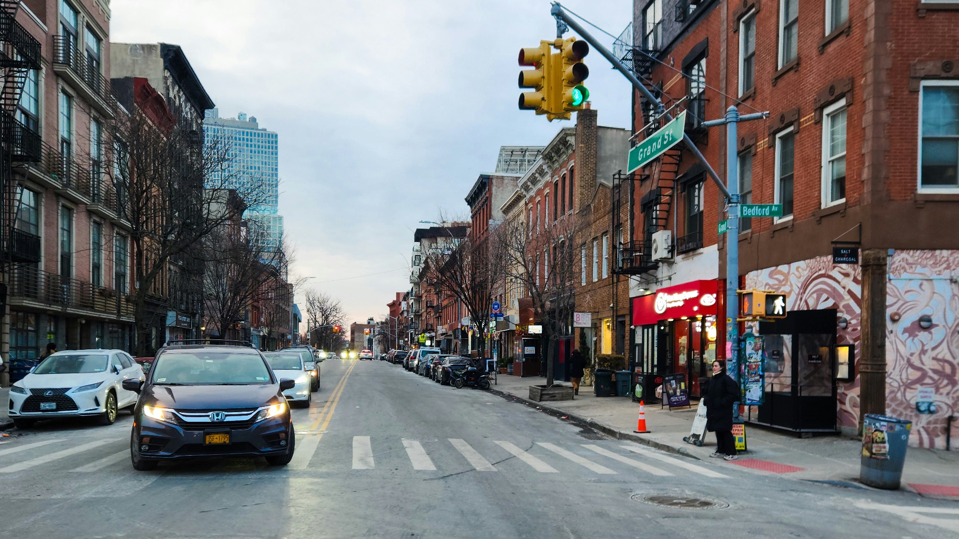 A city street filled with traffic next to tall buildings