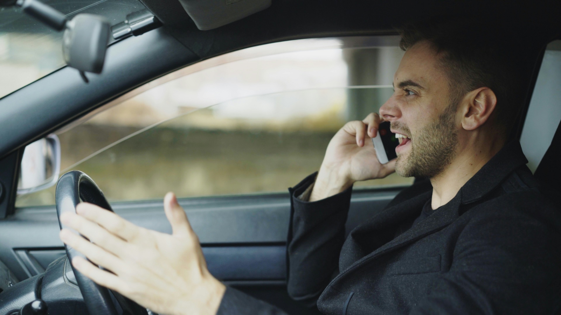 Man talking on phone while driving car