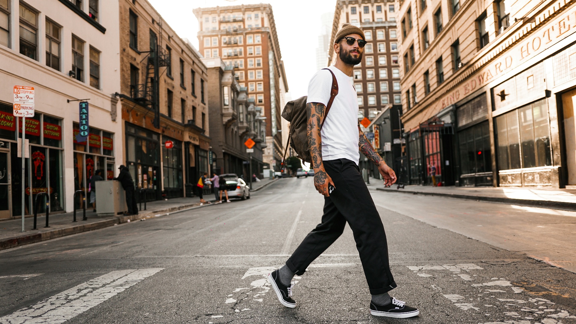 man in white long sleeve shirt and black pants standing on road during daytime