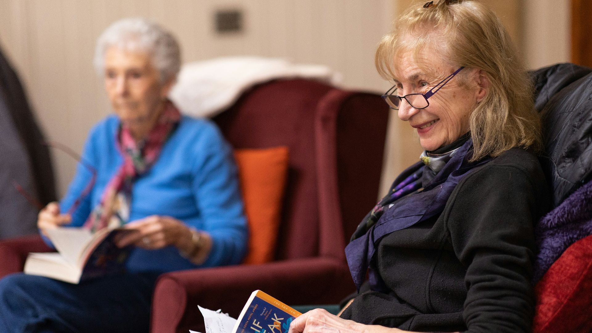 a woman sitting in a chair reading a book