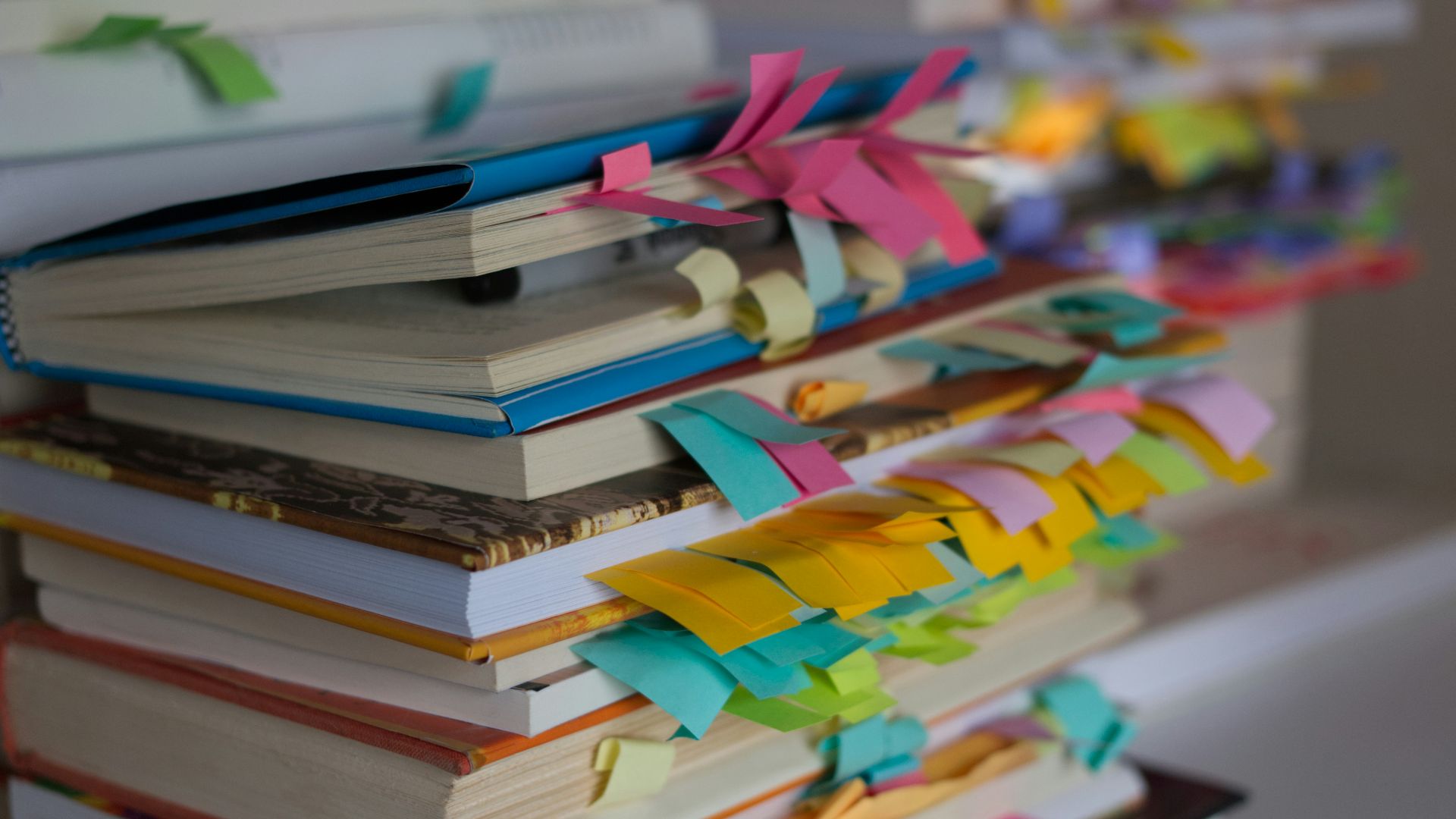 a stack of books with colorful ribbons on them