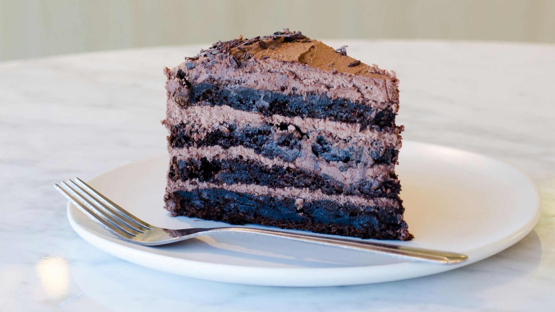 sliced chocolate cake beside fork on plate