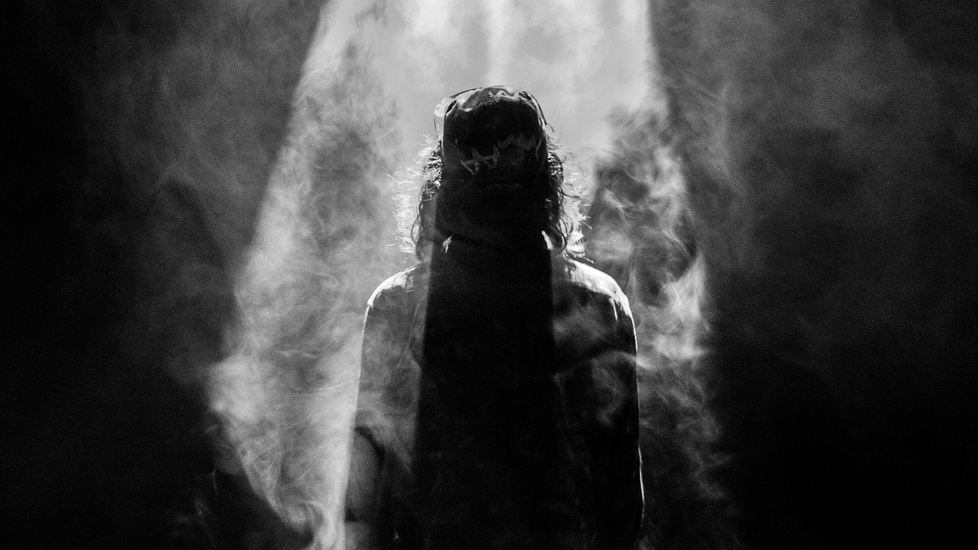 photograph of person facing opposite in smoky spotlight