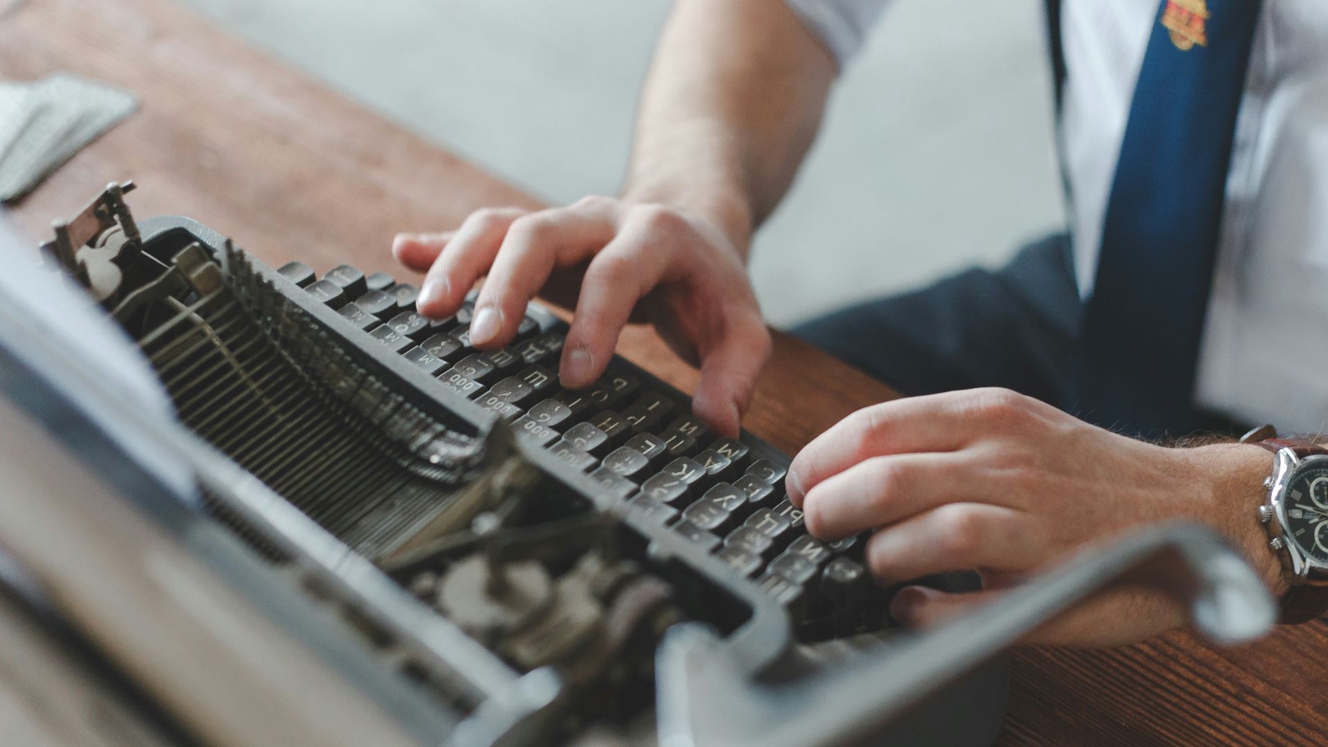 a man typing on an old fashioned typewriter