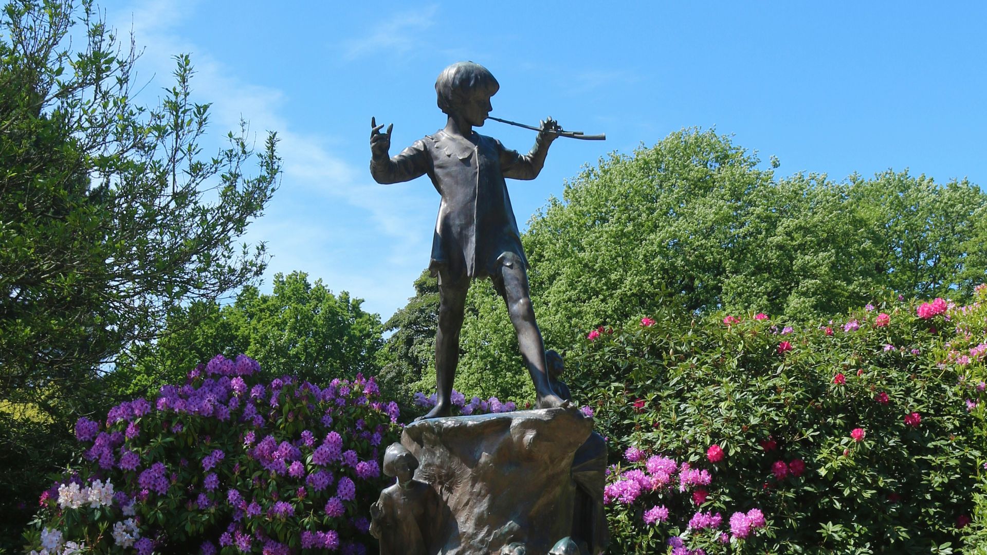 brown statue of man near green trees during daytime