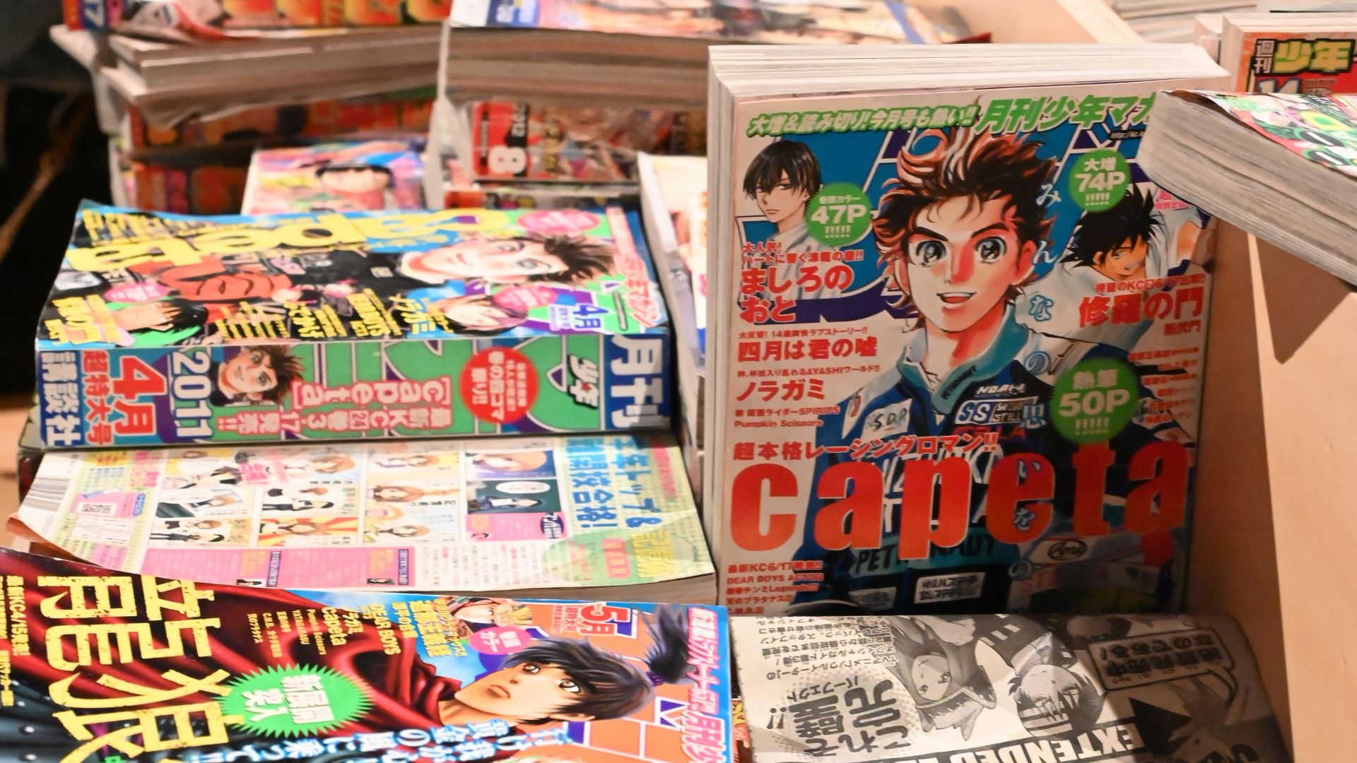 Stacks of japanese comic books are on display.