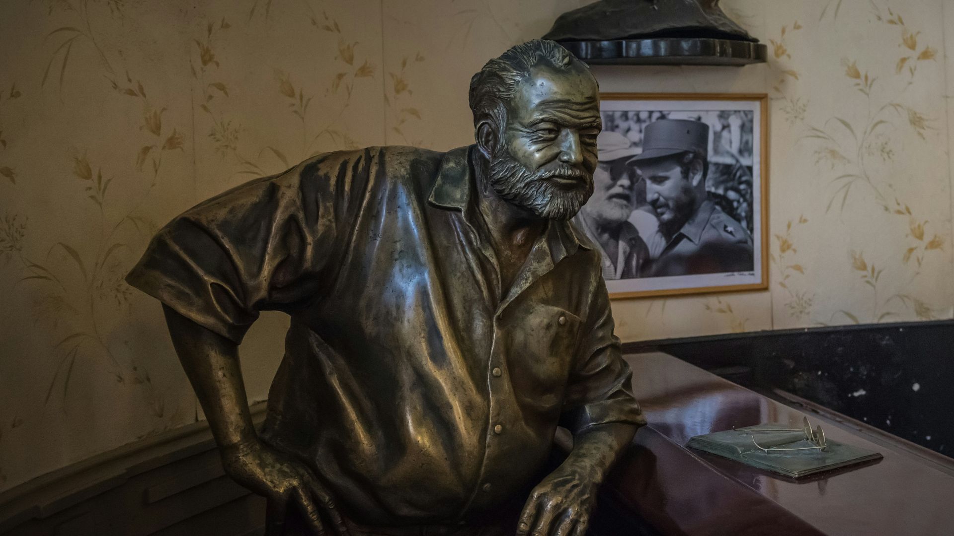 a bronze statue of a man sitting at a desk