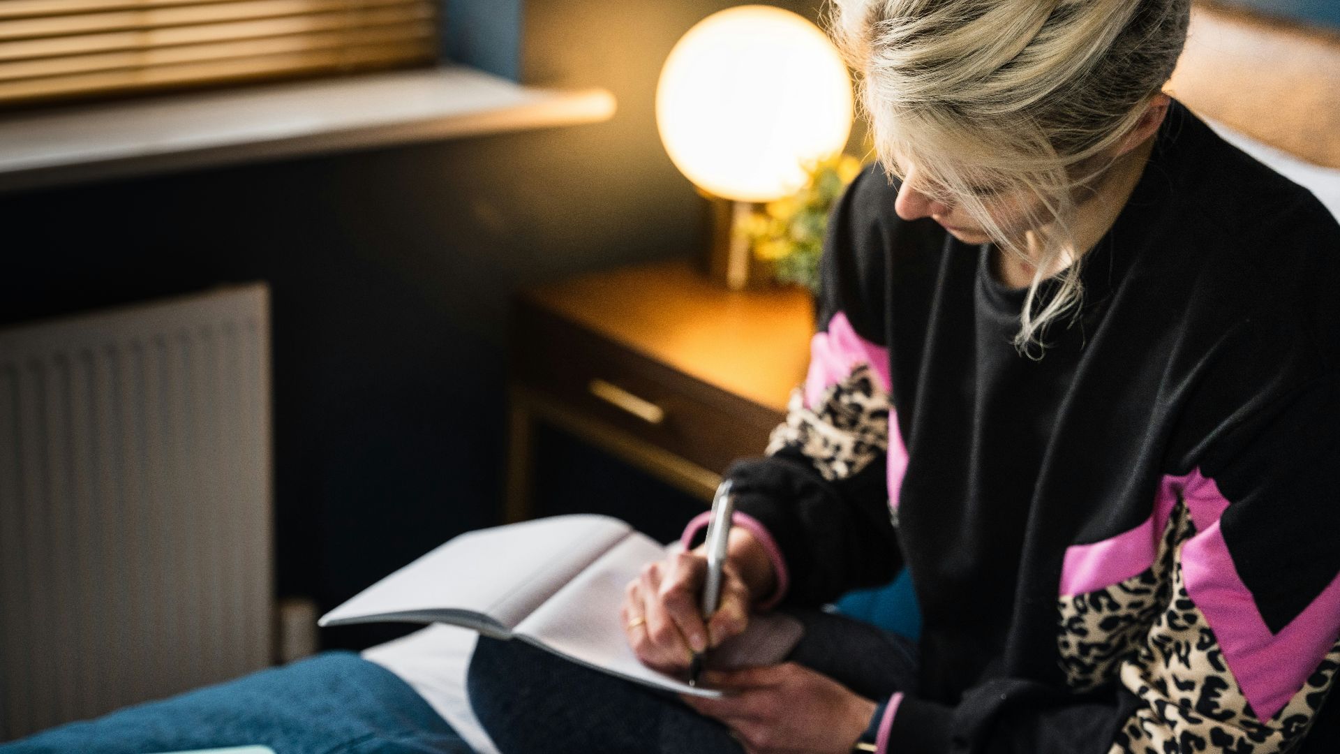 woman in black and white long sleeve shirt sitting on bed