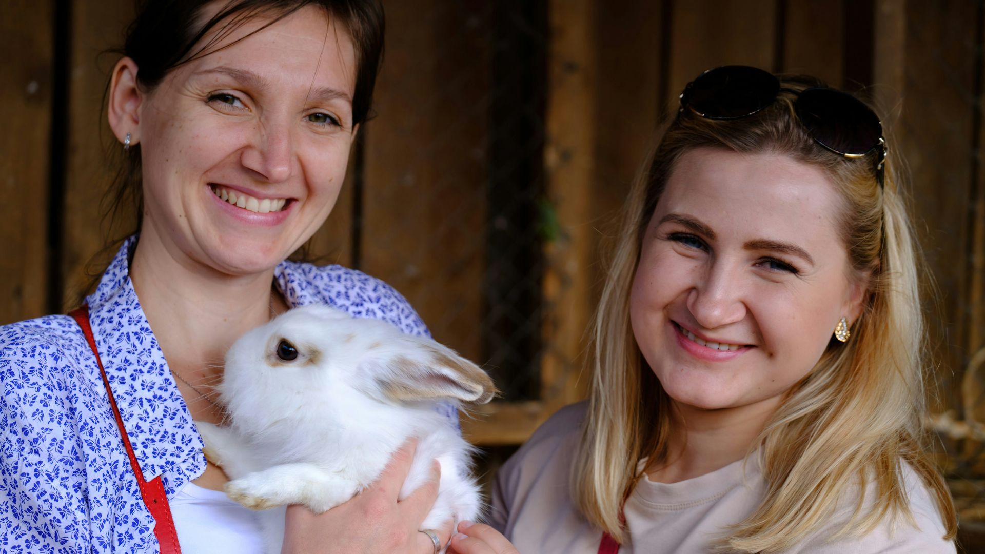 a woman holding a white rabbit in her arms