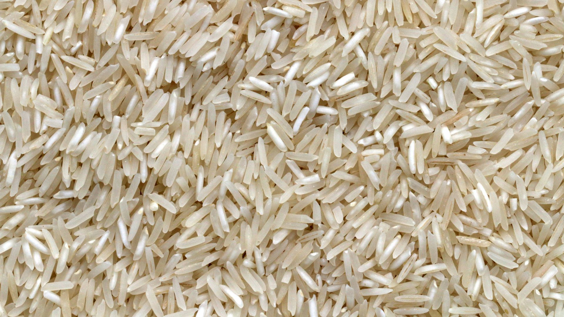 white rice grains on brown wooden table