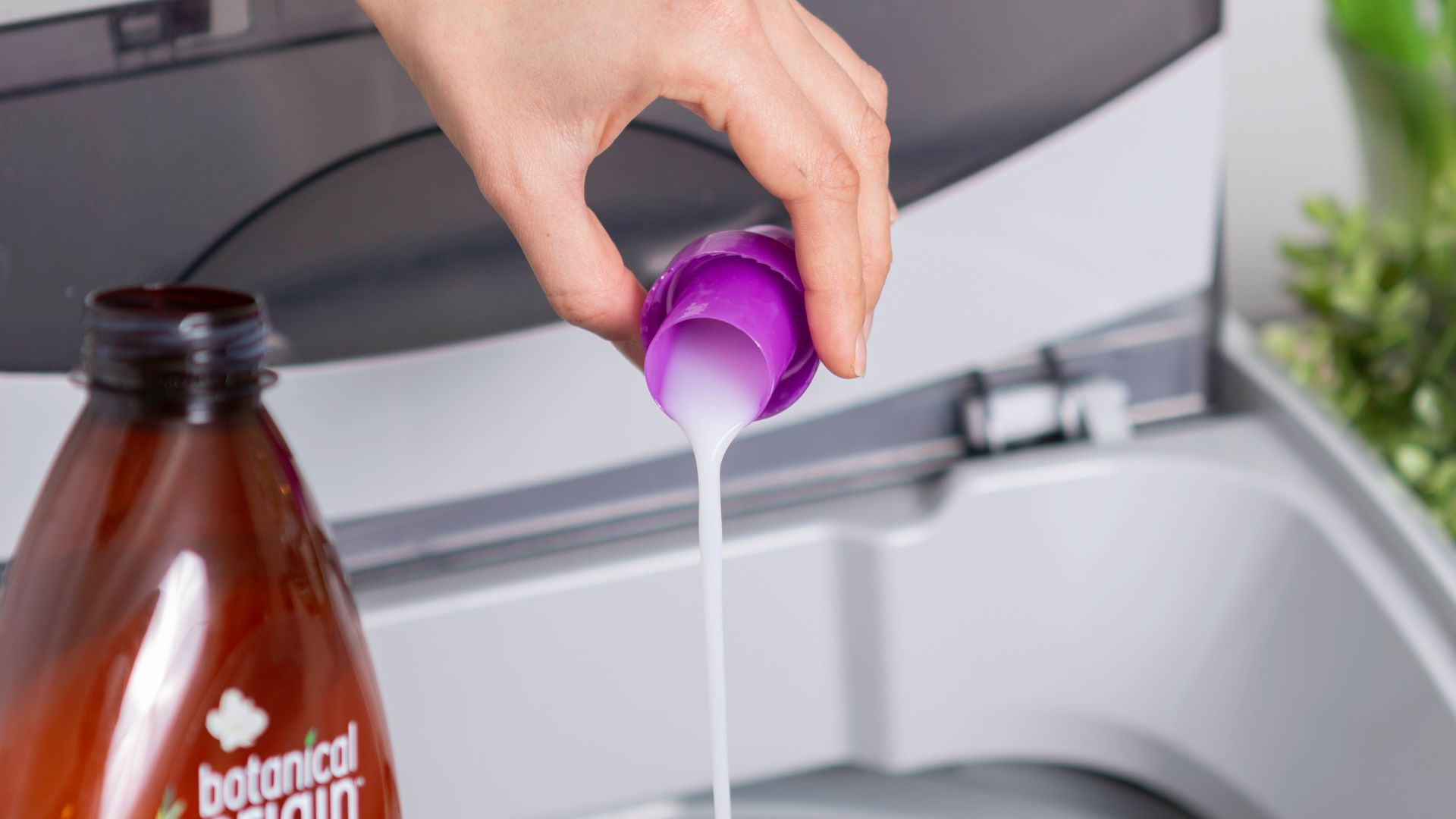 person holding purple plastic bottle