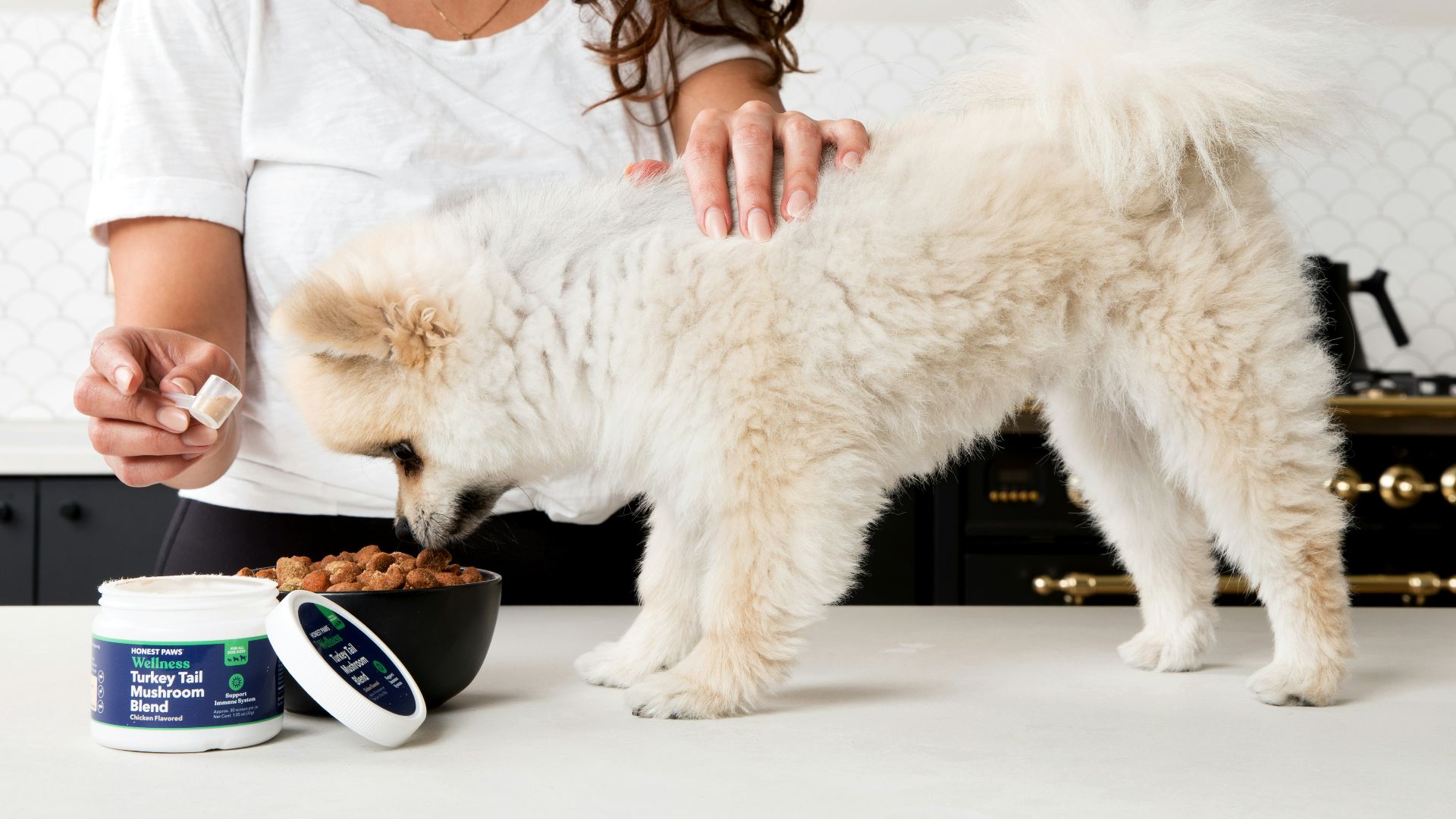 woman in white long sleeve shirt holding blue and white ceramic mug