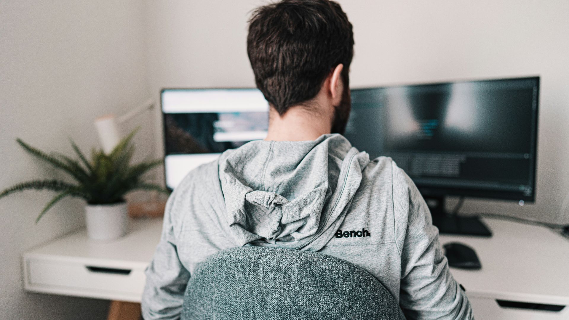 man in gray hoodie sitting on chair