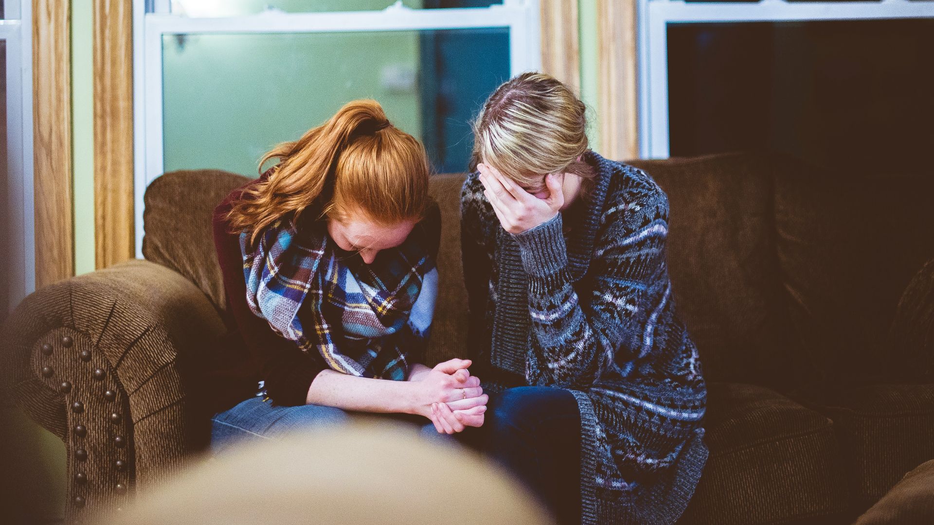 man and woman sitting on sofa in a room