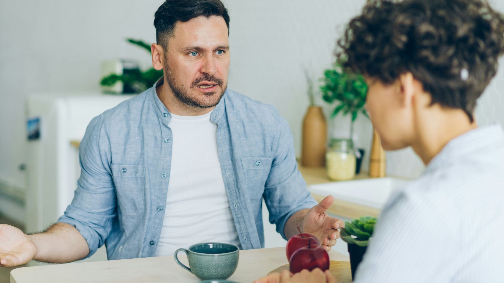 a man sitting at a table talking to a woman