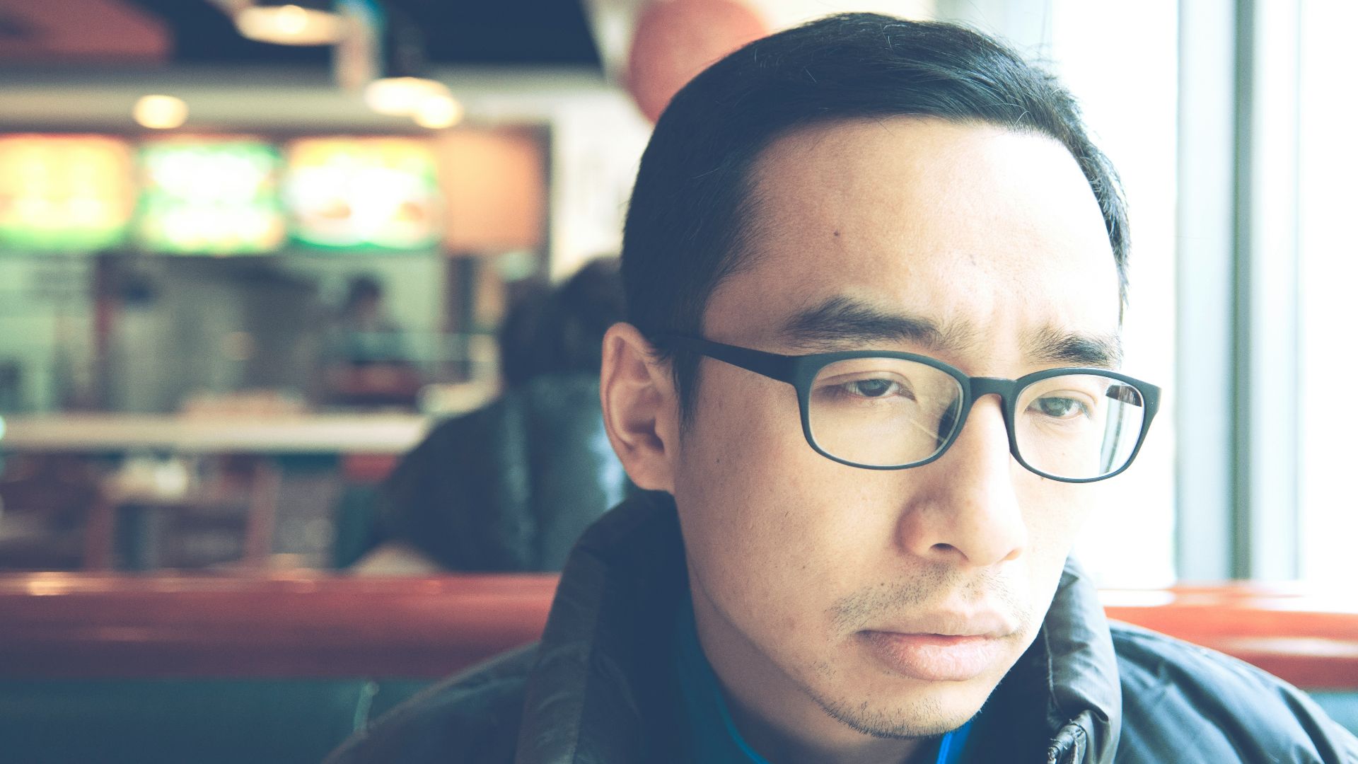 man in black framed eyeglasses and black jacket