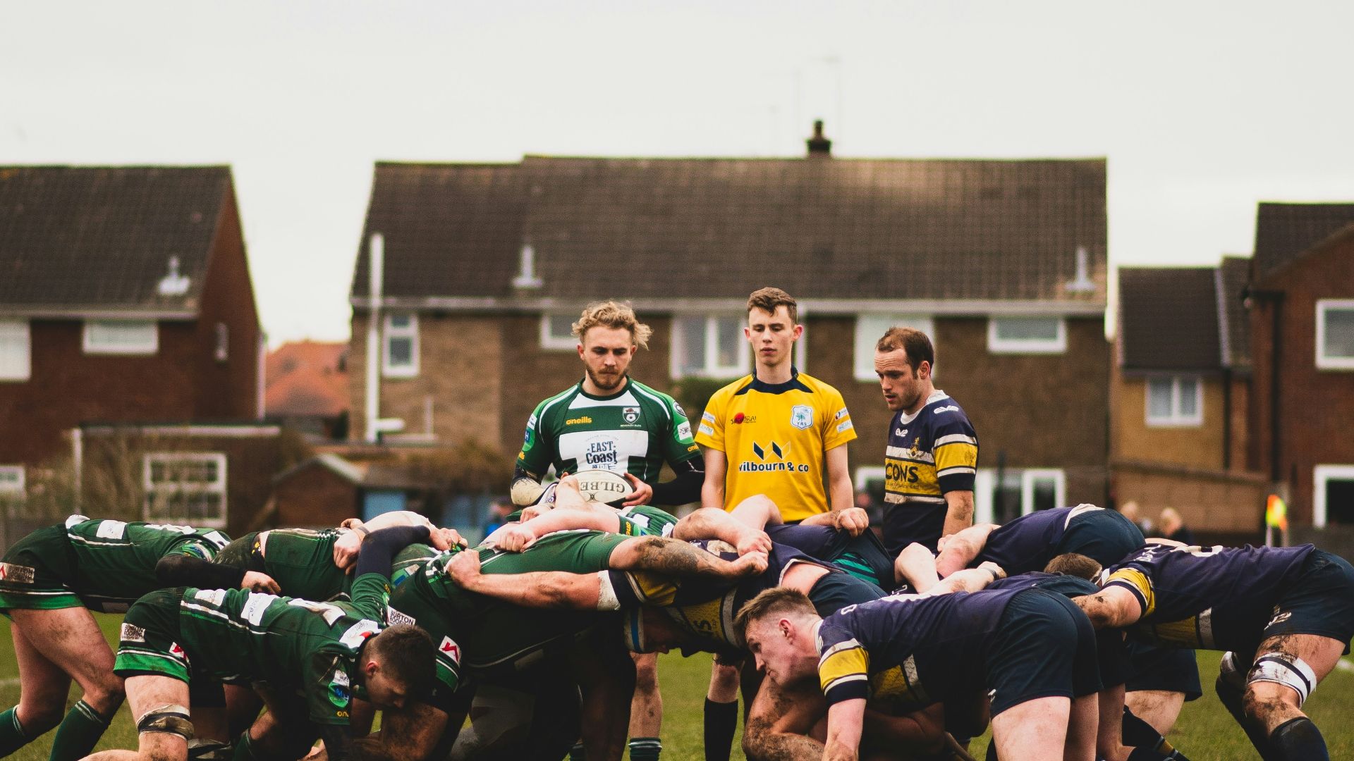 people in yellow and black shirts on green grass field during daytime