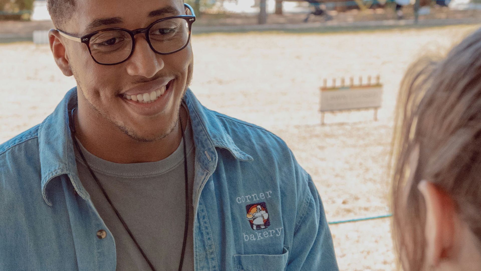 man wearing blue denim button-up shirt facing on human