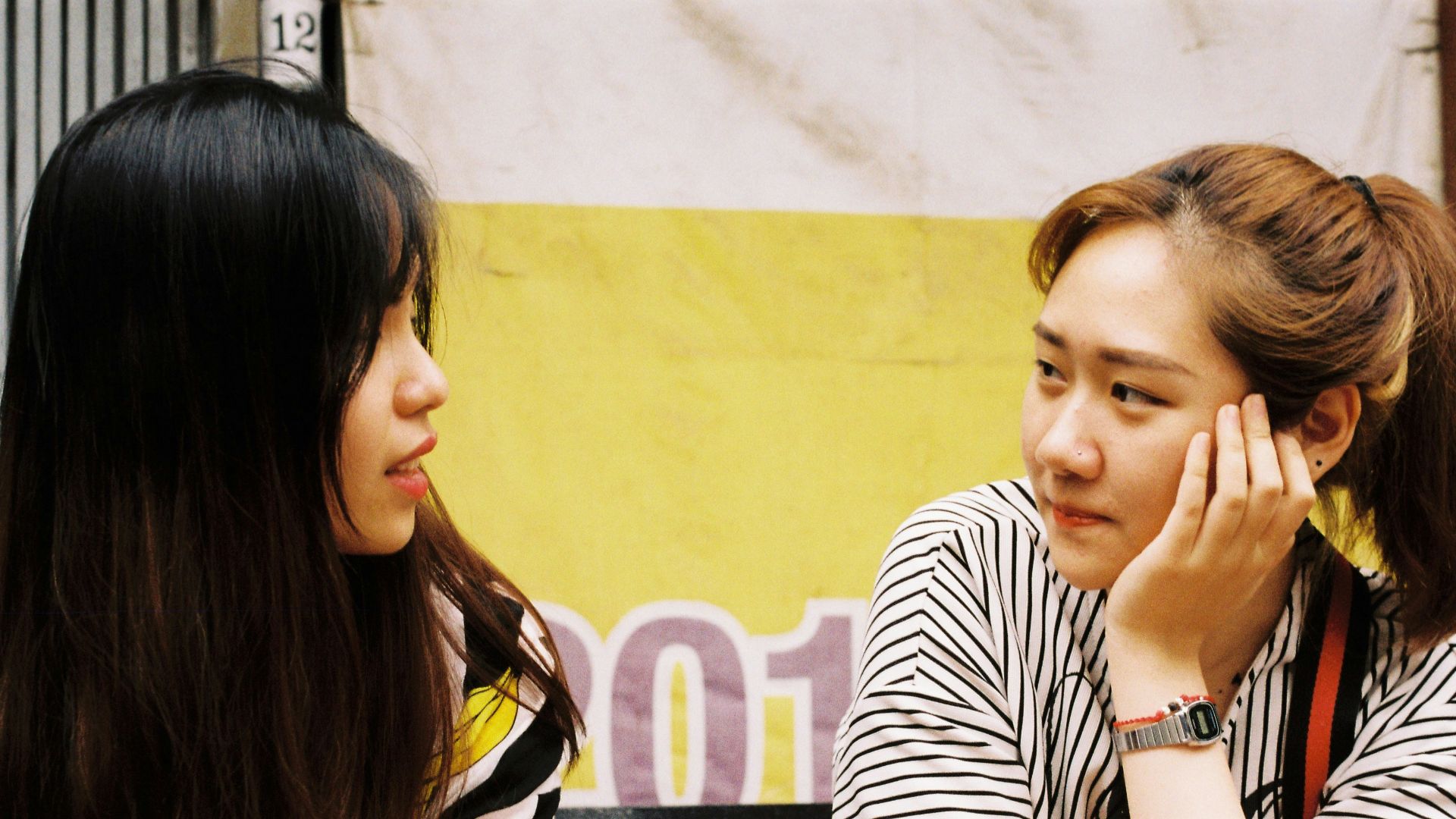 woman in white-and-black striped tops looking each other