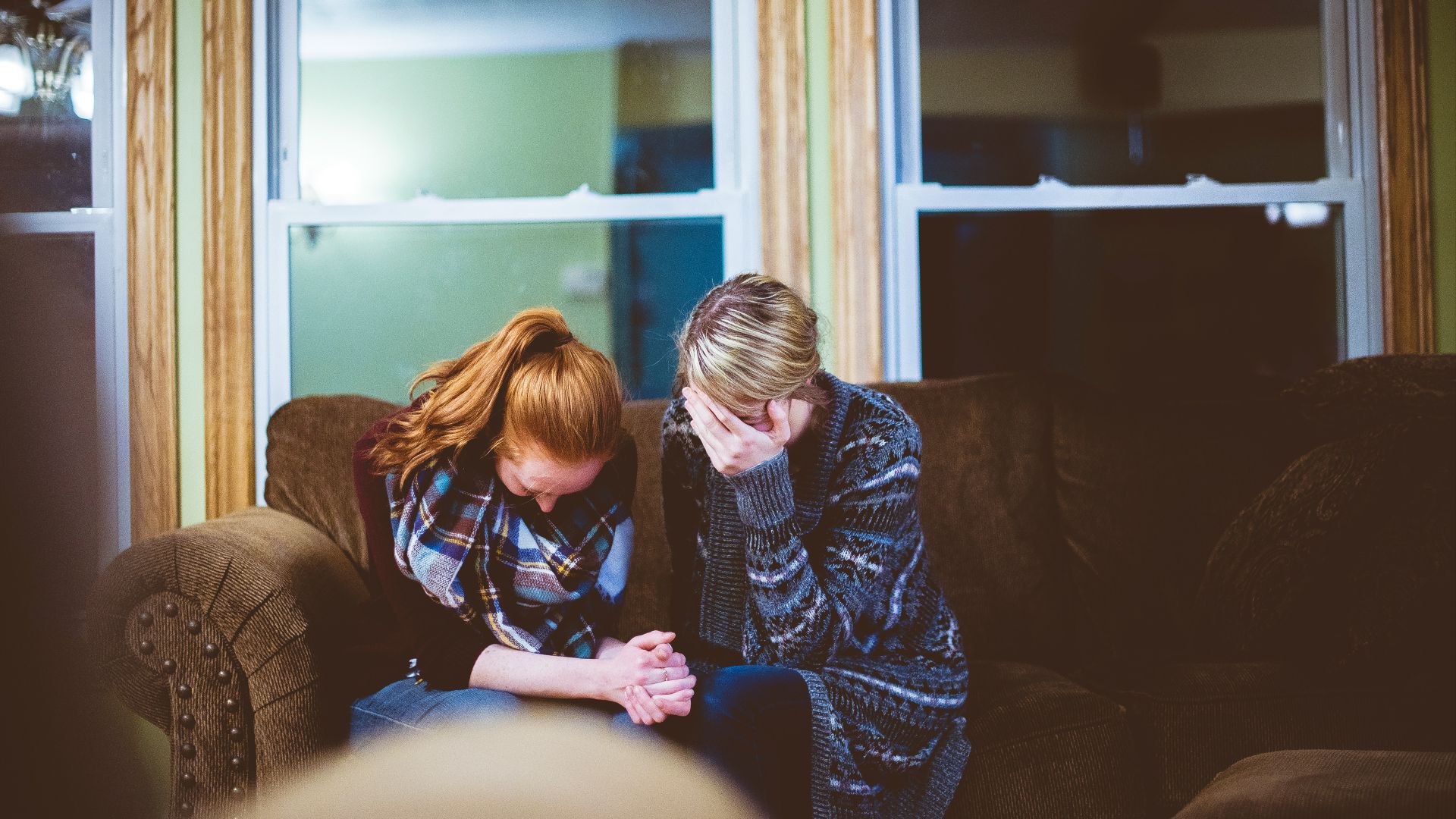 man and woman sitting on sofa in a room