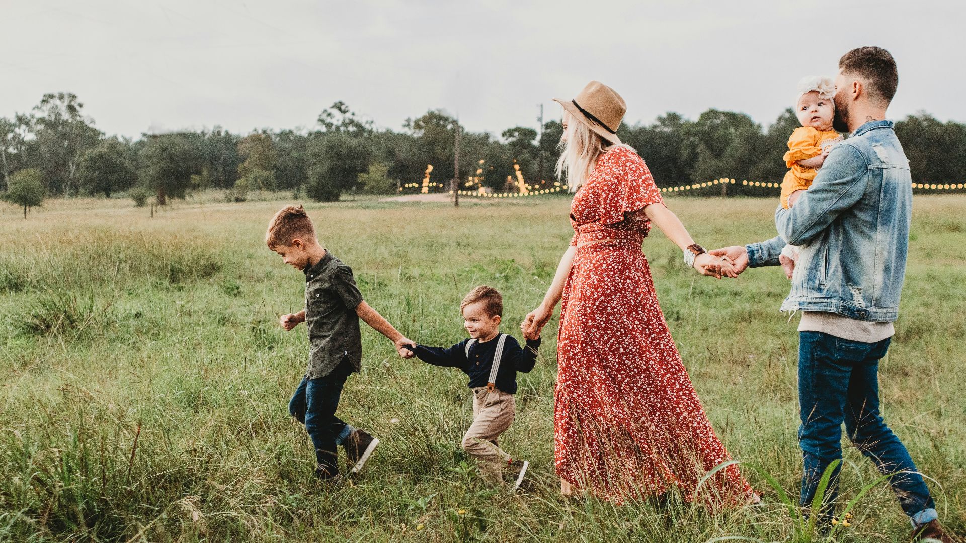 woman holding man and toddler hands during daytime