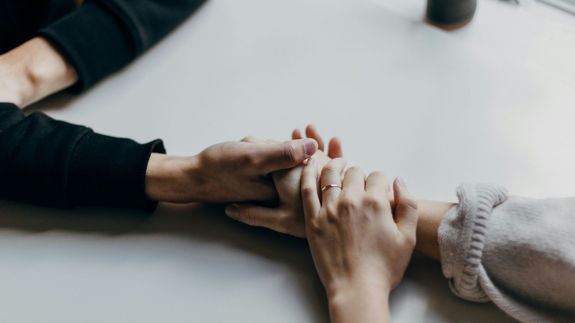 person in black long sleeve shirt holding babys feet
