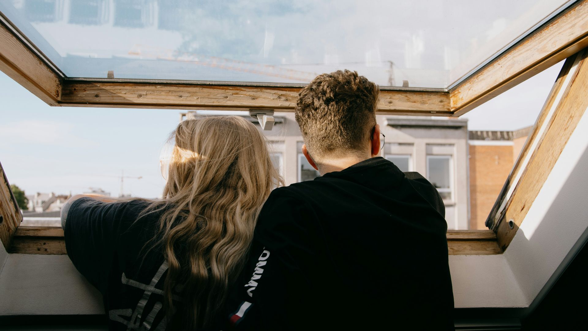 man and woman sitting on black leather couch