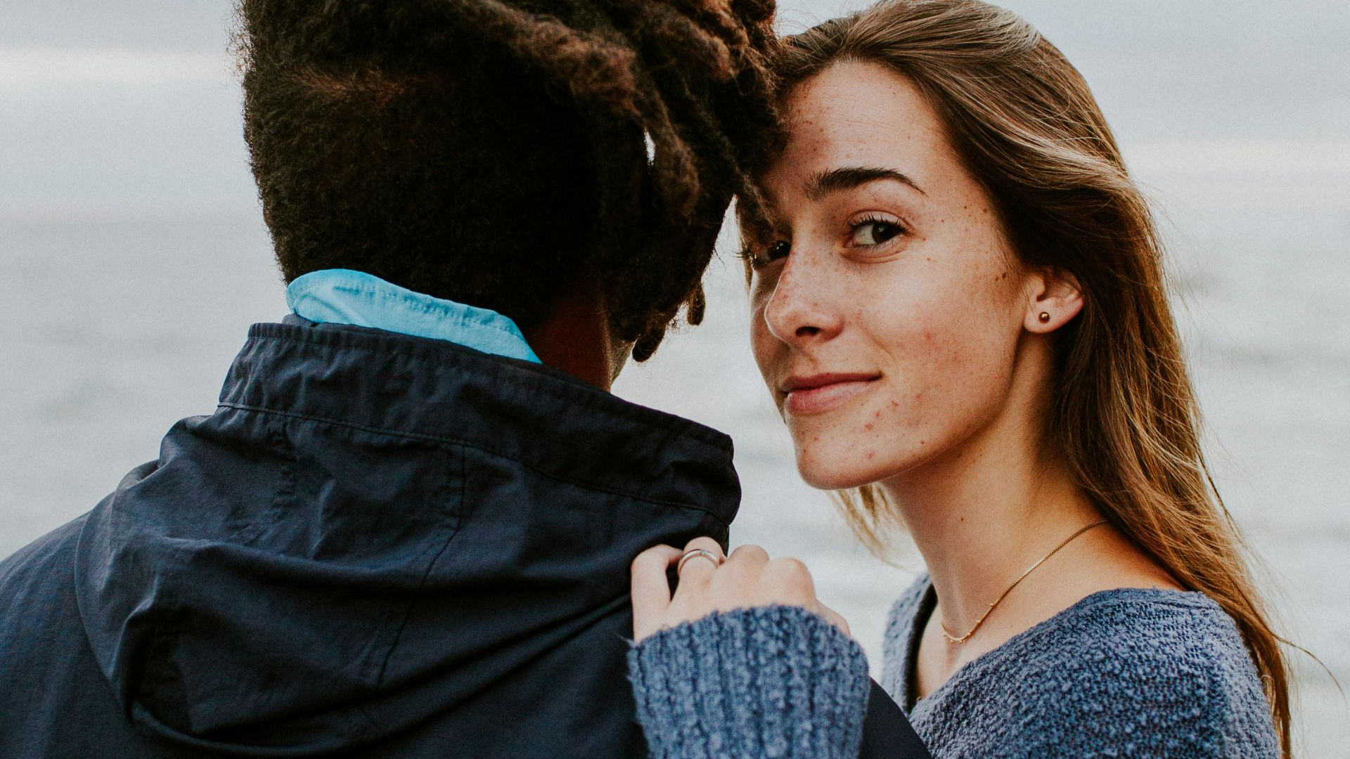 woman in blue long sleeve shirt beside woman in gray long sleeve shirt