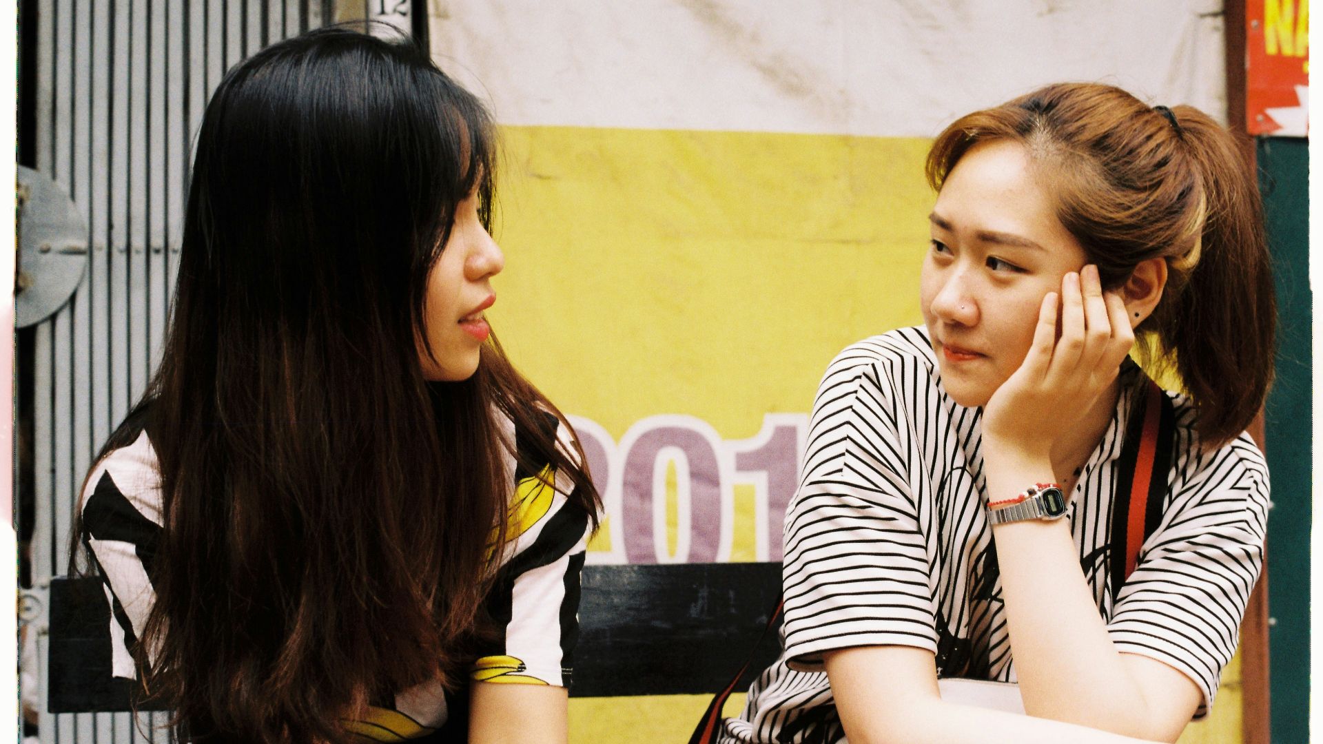 woman in white-and-black striped tops looking each other