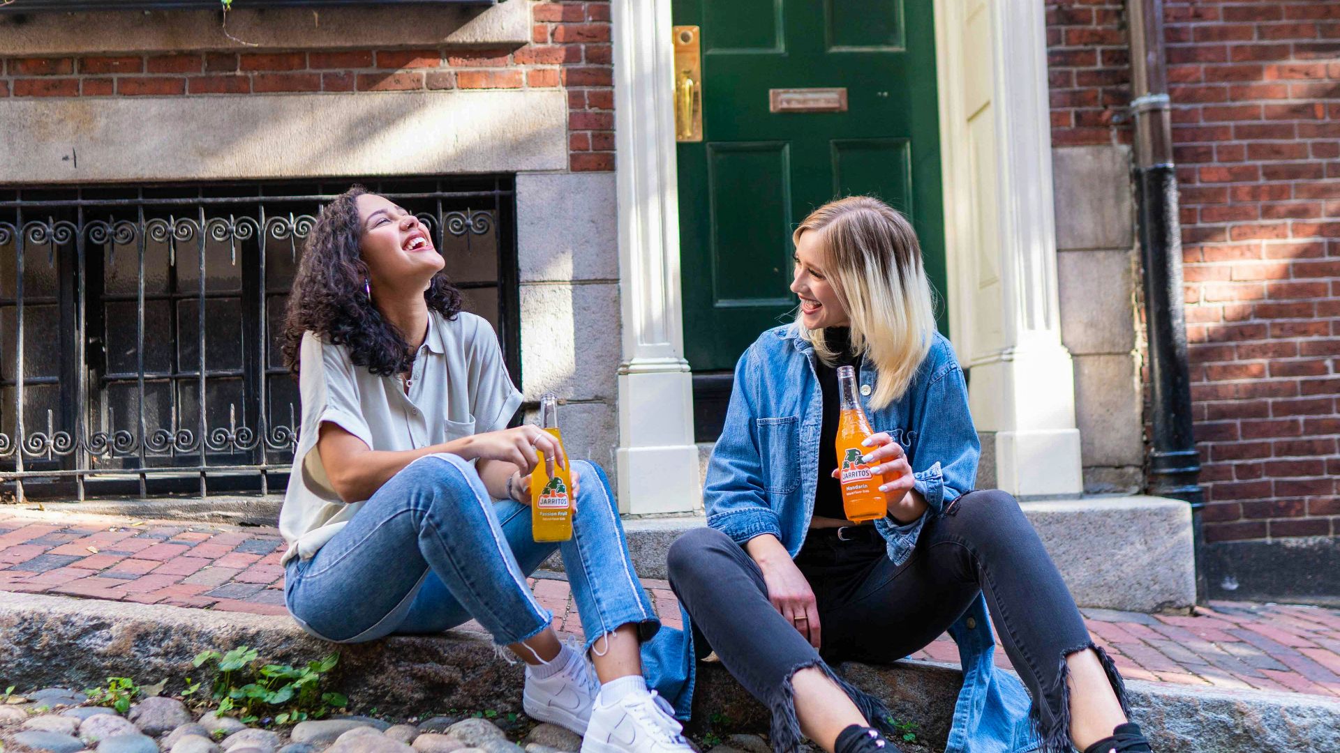 2 women sitting on green grass lawn during daytime
