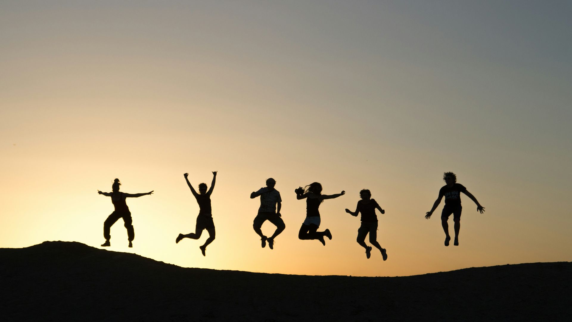 six silhouette of people jumping during sunrise