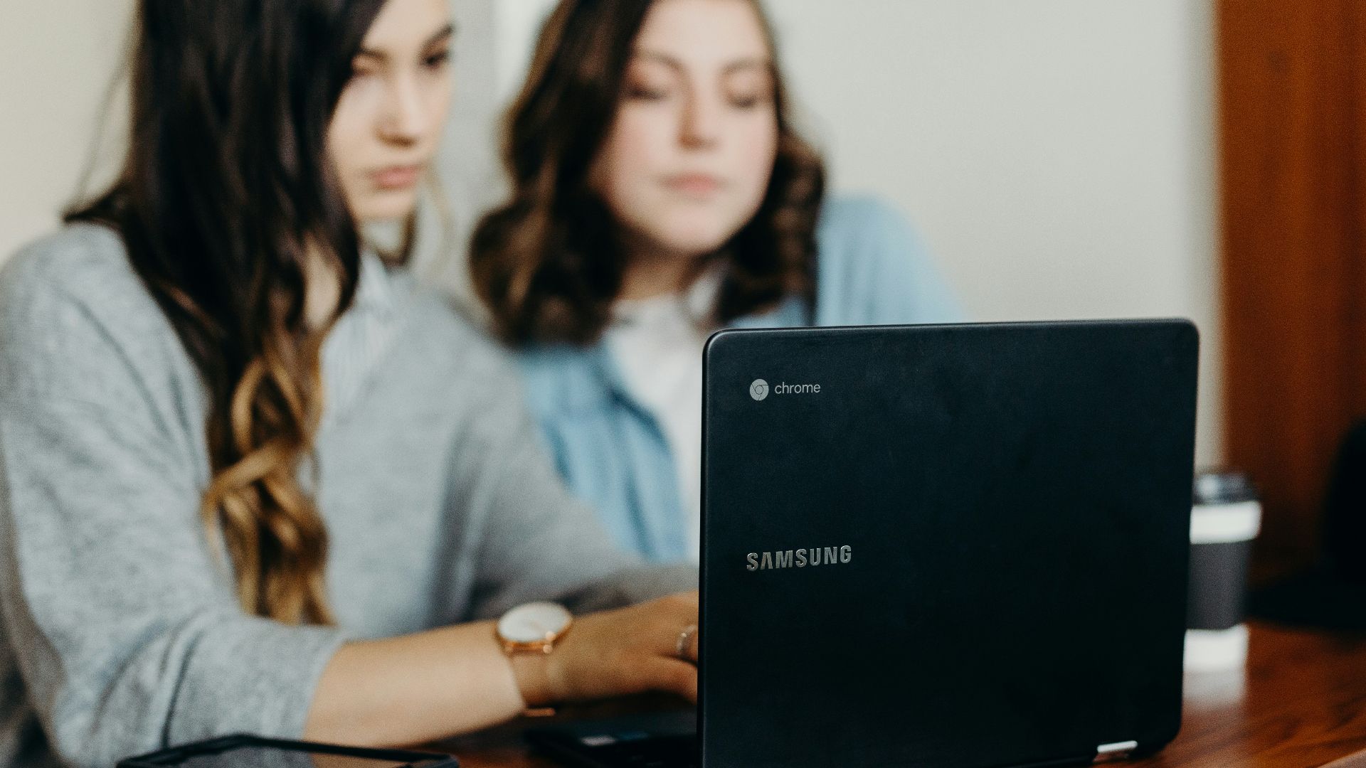 two woman using laptop