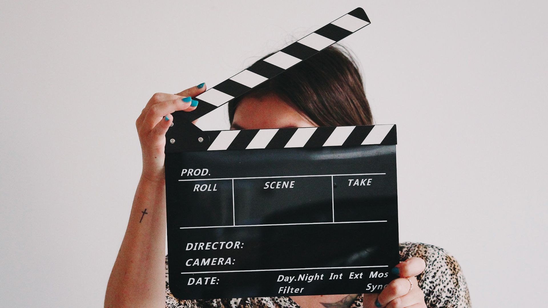a woman holding a clapper over her face