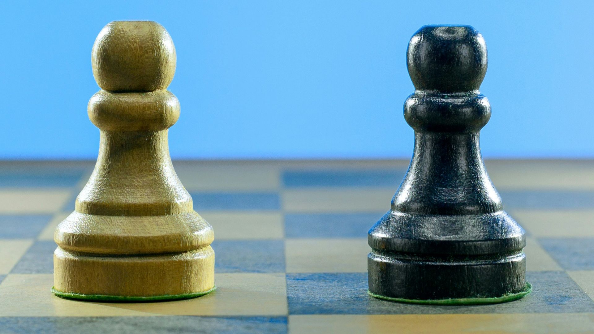 a black and a white chess piece on a checkered board